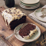 Fondant au chocolat sans gluten avec glacage blanc , tres fondant une part coupé dans une assiette posée sur une planche en bois