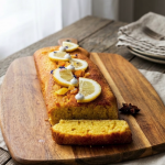 Moelleux au citron sans gluten fondant avec beurre fondu, farine de riz et poudre d'amande, tranché sur planche en bois
