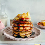 Pile de pancakes châtaigne lupin sans gluten dorés, nappés de sirop, sur assiette