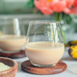 Smoothie à la poudre de baobab crémeux dans un verre, paille et banane à côté