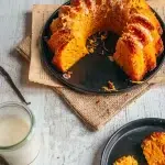 Carrot cake sans gluten et sans lactose nappé de glaçage, une part coupée