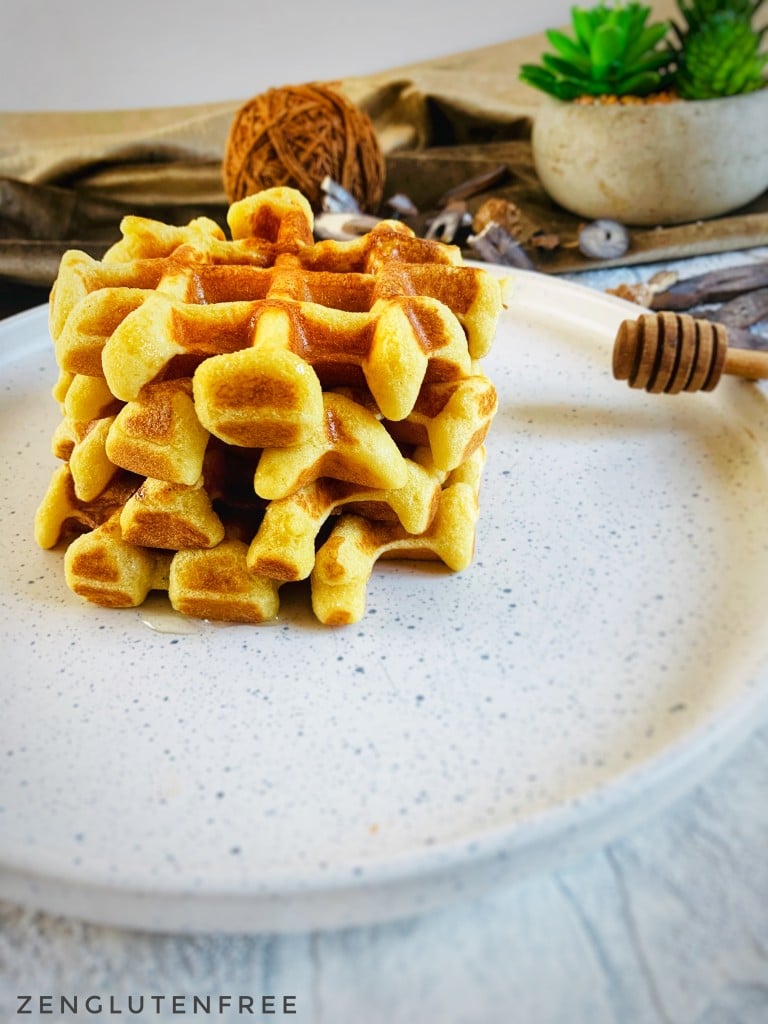 Gaufres liégeoises sans gluten croustillantes et dorées empilées sur une assiette blanche avec un filet de sirop