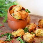 Accras de légumes sans gluten vegan dorés et croustillants à la courge et carottes dans un bol en terre cuite avec persil frais et baies roses
