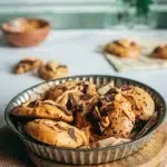 Cookies moelleux vegan sans gluten au beurre de cacahuète et chocolat dans un moule métallique sur planche en bois