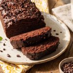 Gâteau chocolat courgette sans gluten fondant avec chocolat noir farine de sarrasin farine de noix et courgette râpée tranché sur planche en bois