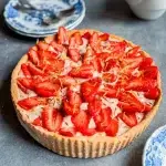 Tarte aux fraises végétale sans gluten avec pâte sablée dorée crème pâtissière vanille et fraises fraîches disposées en rosace