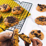 Cookies moelleux sans gluten ig bas fondants à la farine de pois chiche coupés en deux avec de grosses pépites de chocolat noir sur une grille