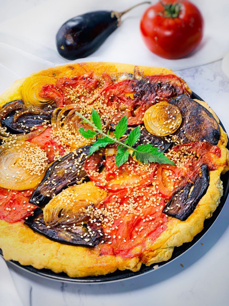 Tarte tatin de légumes sans gluten vegan colorée avec tomate aubergine oignon et vinaigre balsamique démoulée sur assiette