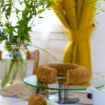 Gâteau châtaigne souchet sans gluten moelleux tranché, sur une assiette avec autour des dleur et une fenetre