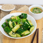 Salade de concombres à la japonaise écrasés avec marinade tamari sésame, graines de sésame et coriandre dans un bol blanc avec baguettes