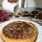 Tarte aux noix de pécan sans gluten croustillante sous un filet de sirop d'érable avec une pâte sablée dorée aux épices