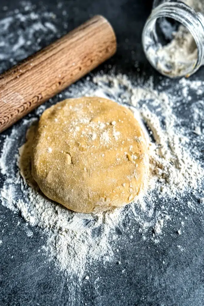 Pâte sablée sans gluten croustillante avec farine de riz farine de pois chiche fécule de maïs cannelle et muscade étalée dans moule à tarte
