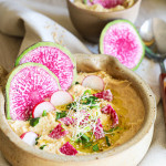 Houmous express sans gluten dans un bol, filet d'huile et paprika, bâtonnets de légumes autour