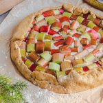 Une tarte à la rhubarbe sans gluten sans lactose entière avec pâte sablée dorée et crème d'amande