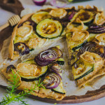 Tarte fine courgette chèvre miel sans gluten avec oignon rouge et miel sur pâte brisée dorée