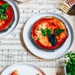 Pizza courgette sans gluten avec sauce tomate, mozzarella fondue et basilic frais, servie sur assiette blanche
