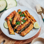 Bâtonnets de courgettes rôtis au sésame et parmesan, dorés et croustillants sur plaque de cuisson