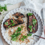 Aubergines rôties à la japonaise sans gluten caramélisées au miso et sésame, servies sur riz dans une assiette blanche avec coriandre fraîche