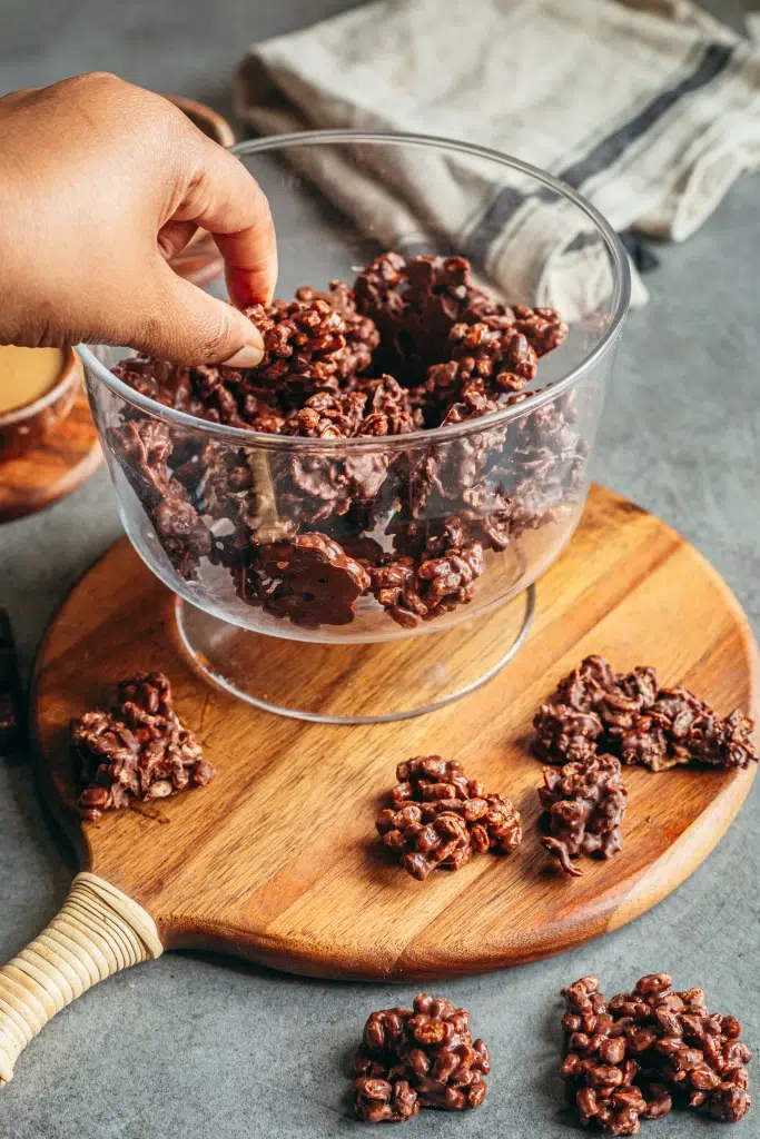 Bouchées croustillantes chocolat cacahuète sans gluten dans un bol en verre avec pétales de maïs enrobés de chocolat noir
