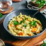 Blanquette de haricots blancs sans gluten crémeuse dans une cocotte, carottes et champignons visibles