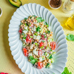 Salade de pois chiches sans gluten avec tomates cerises concombre feta et coriandre fraîche sur assiette blanche