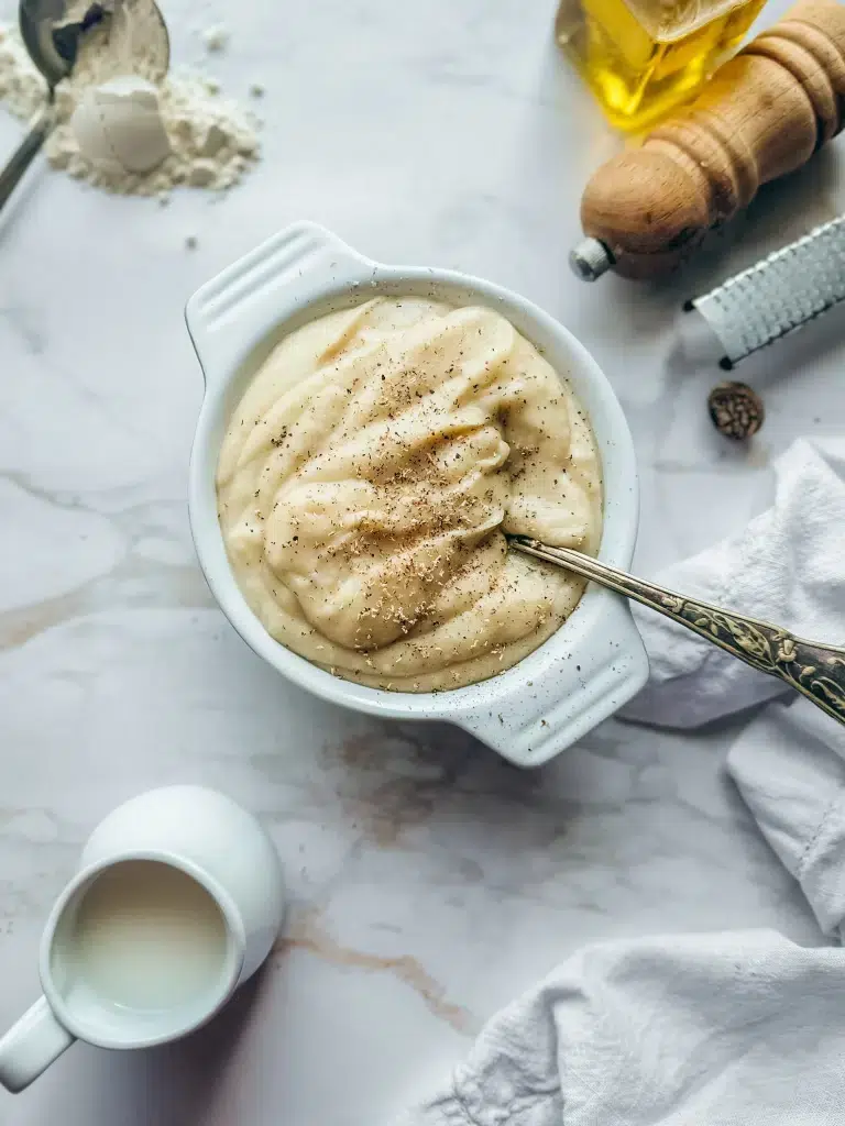 Sauce béchamel sans gluten sans lactose onctueuse et crémeuse dans un plat blanc avec farine de riz et lait végétal
