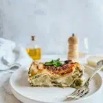 Lasagnes brocolis chèvre sans gluten bien gratinées avec béchamel crémeuse et chèvre fondant sur assiette blanche