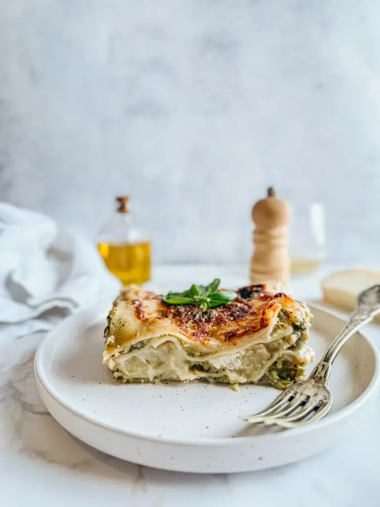 Lasagnes brocolis chèvre sans gluten bien gratinées avec béchamel crémeuse et chèvre fondant sur assiette blanche