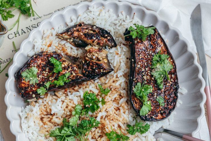 Aubergines rôties à la japonaise sans gluten caramélisées au miso et sésame, servies sur riz dans une assiette blanche avec coriandre fraîche